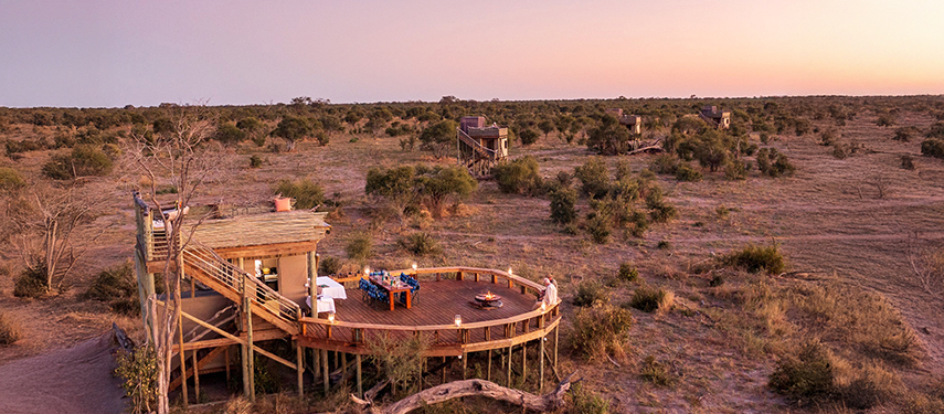 Lantern-lit dining deck at Skybeds with panoramic views across the open savannah.