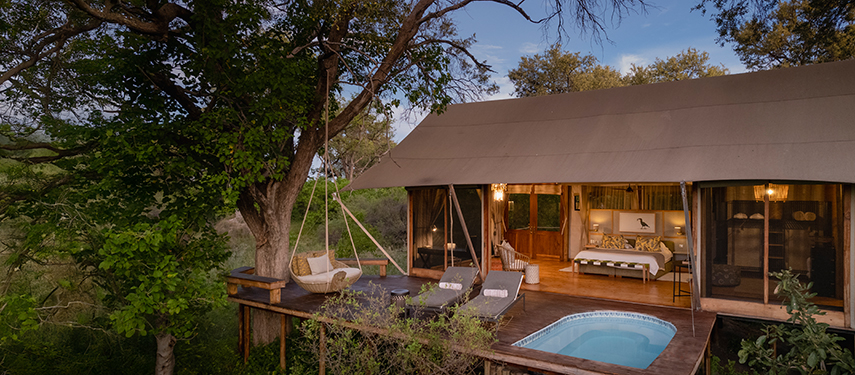 Luxurious tented suite at Tuludi Camp with private plunge pool and shaded deck surrounded by lush green bushveld.