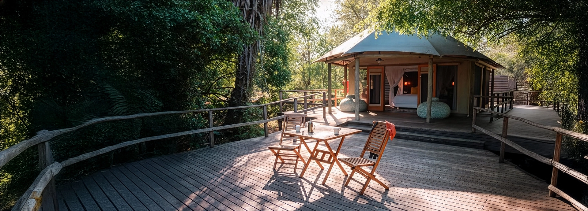 A spacious private deck fronts a circular tented suite, with outdoor seating arranged for relaxed afternoons immersed in nature.