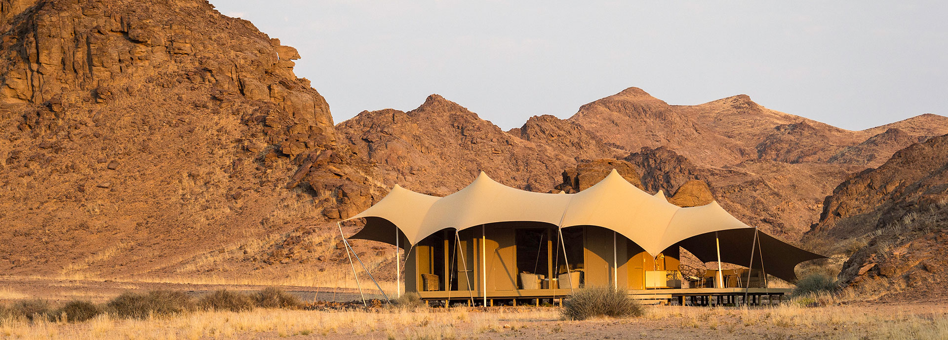 Luxury tents perched in between rugged hills in the desert at Hoanib Skeleton Coast