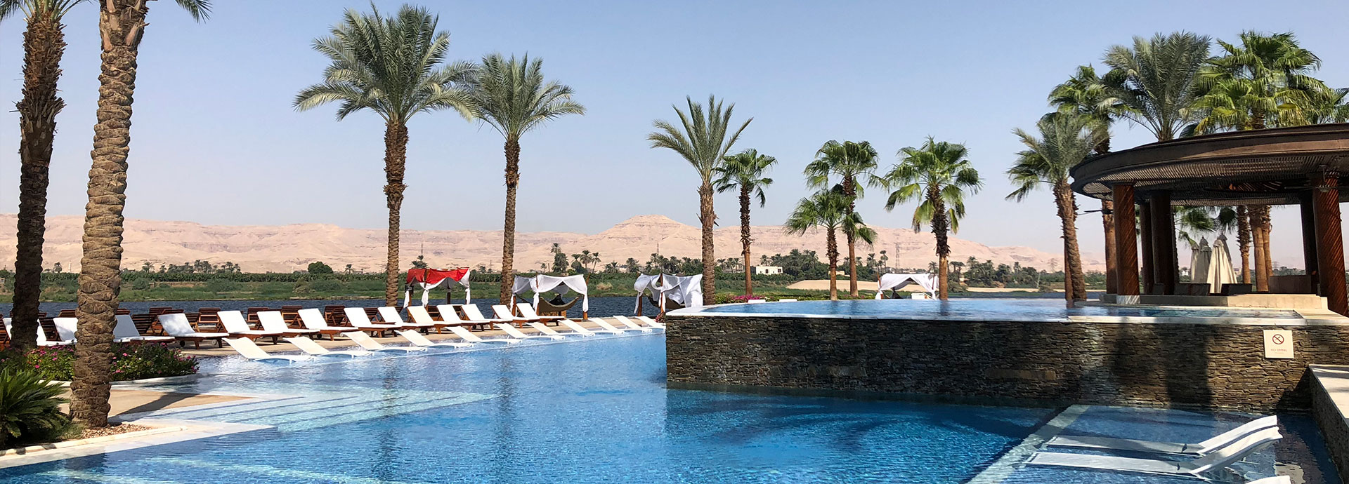 Palm trees, pool and refreshment overlooking the Nile at the Hilton Luxor Resort & Spa