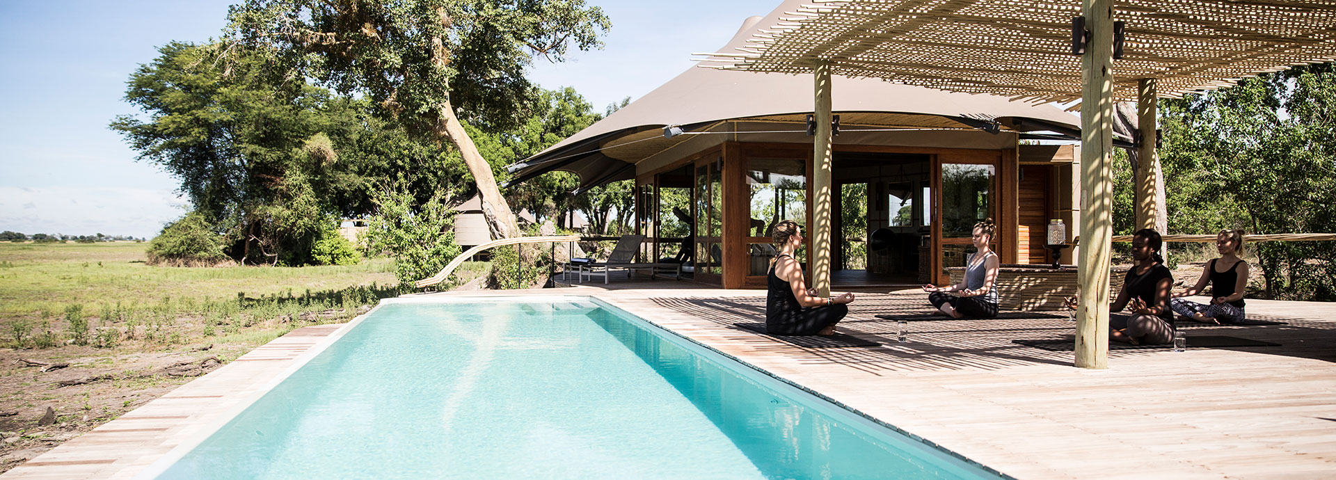 Guests do Yoga By The Pool at Mombo luxury safari camp, Botswana