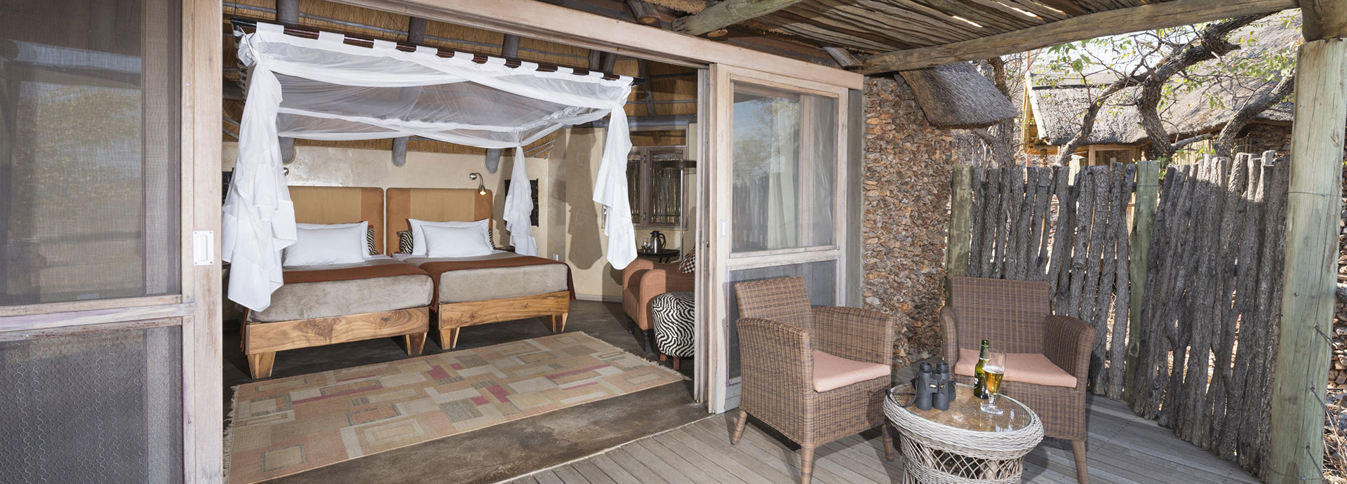 Four poster beds with wooden interiors at Ongava Lodge