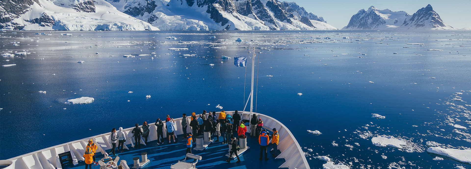 Tourists view ice floes aboard a ship in Antarctica