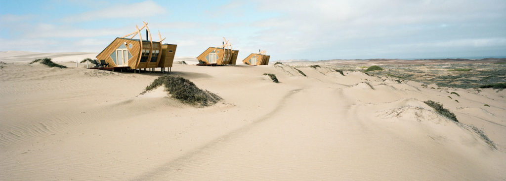 Cleverly designed shipwreck-style cabins are scattered over sand dunes at Shipwreck Lodge in Namibia