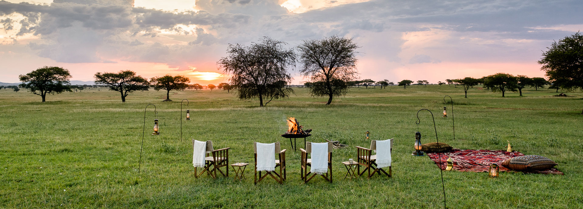 Gather around the campfire for sundowners with views of the Grumeti Reserve at Singita Sabora