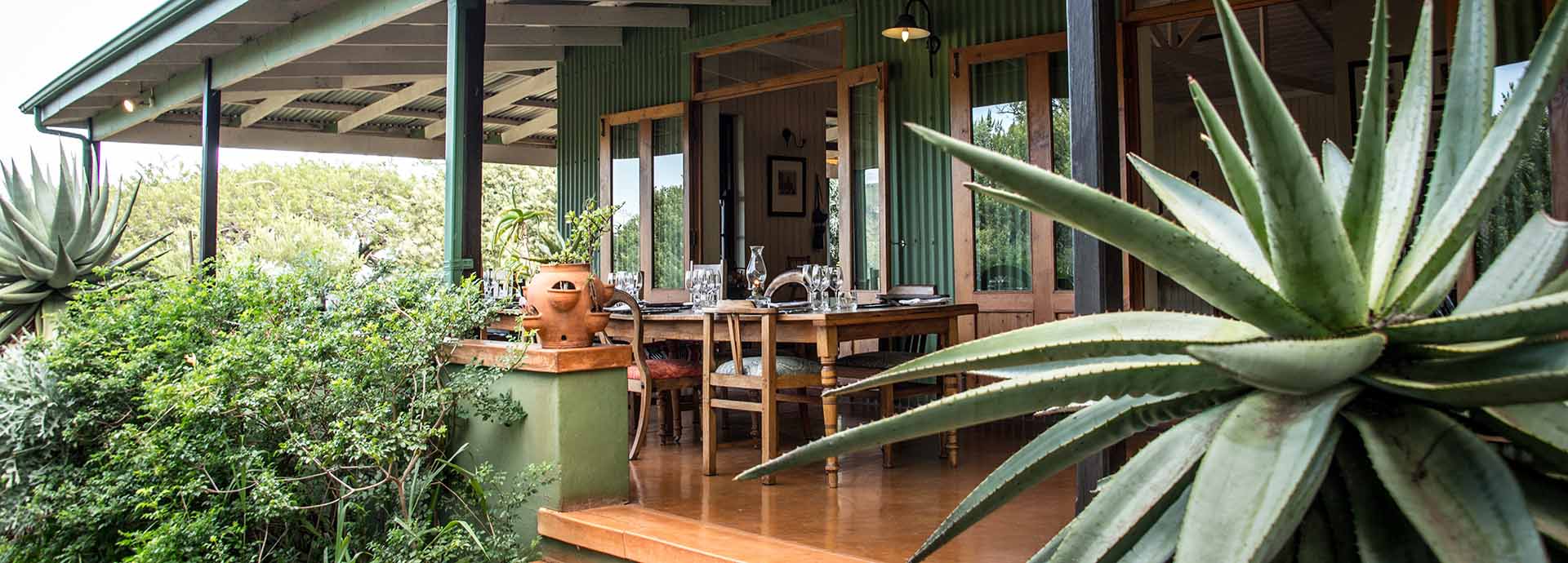 Share stories over a meal on the verandah from the main lounge at Three Tree Hill in South Africa