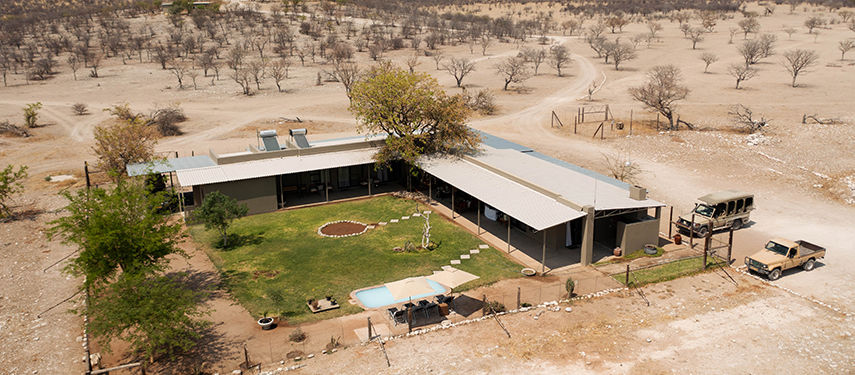 An aerial view of Safari House showing its courtyard, swimming pool, and surrounding dry bushland.