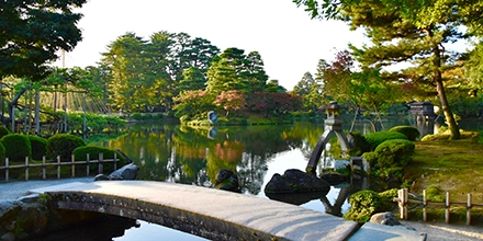 A serene view across Kenrokuen Garden in Kanazawa, reflecting seasonal colour, stone lanterns and classical Japanese landscaping.