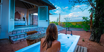 Woman in open-air bathroom at Nantwich Lodge, Hwange National Park