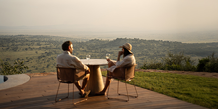 Couple enjoying stunning sunset views over the Serengeti from Singita Milele luxury safari lodge