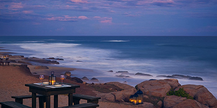 A time-lapse sunset image of the Sri Lankan coast with waves crashing on rocks