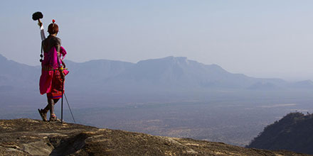 Lone Maasai tribesman standing on a bare rock ridge in the Mathews Range of Kenya