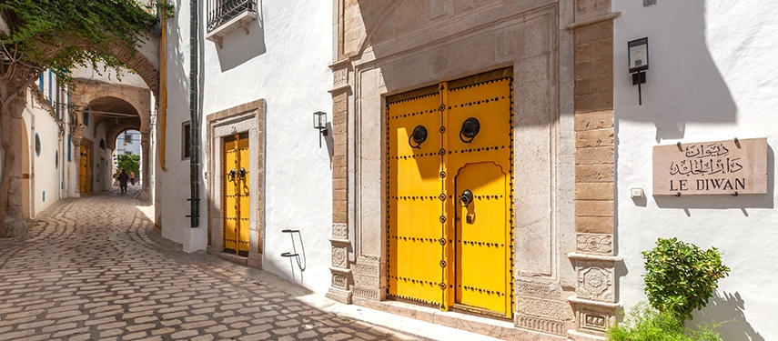 Bright yellow traditional Medina doors marking the entrance to Dar El Jeld Hotel & Spa.