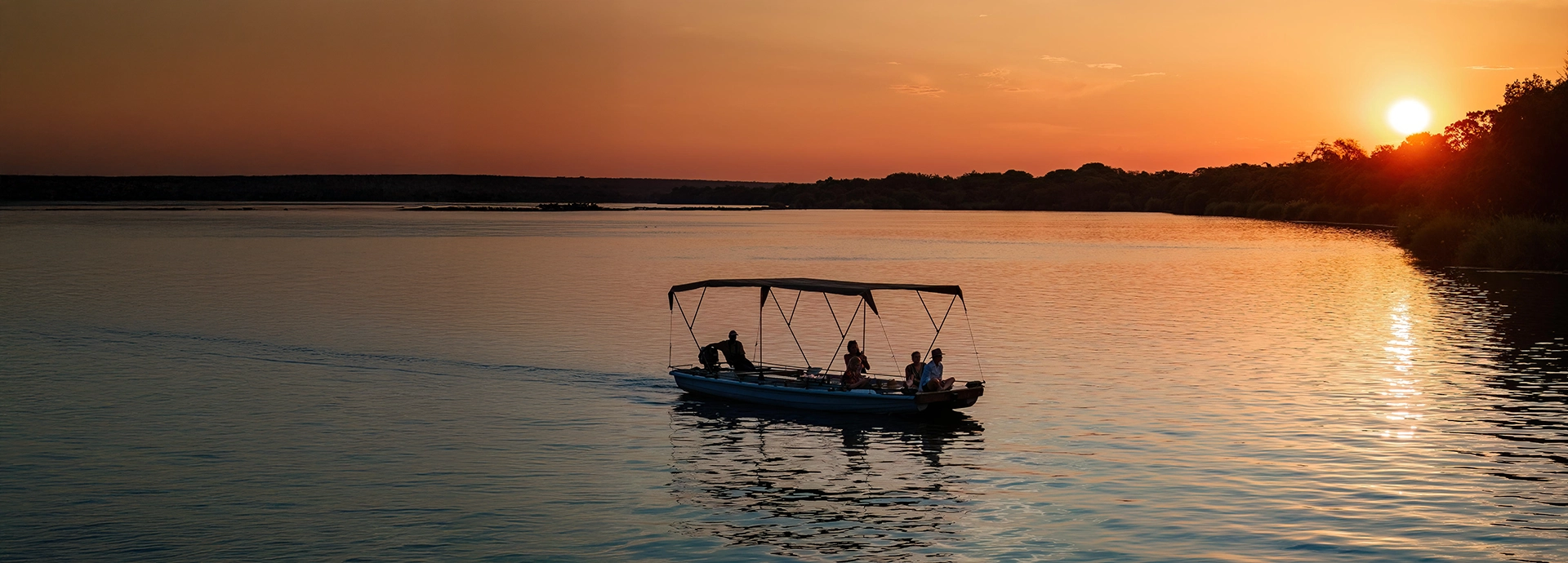 A sunset cruise on the Zambezi River offers tranquil views as the sky glows with warm evening colour near Livingstone.