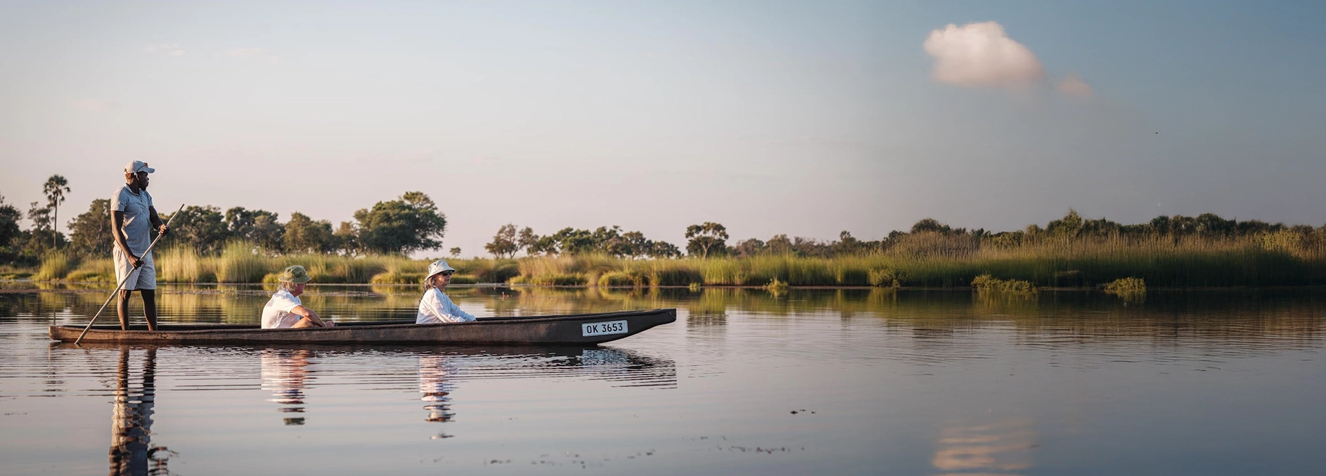 Guests enjoying a tranquil mokoro excursion on the waterways of the Okavango Delta.