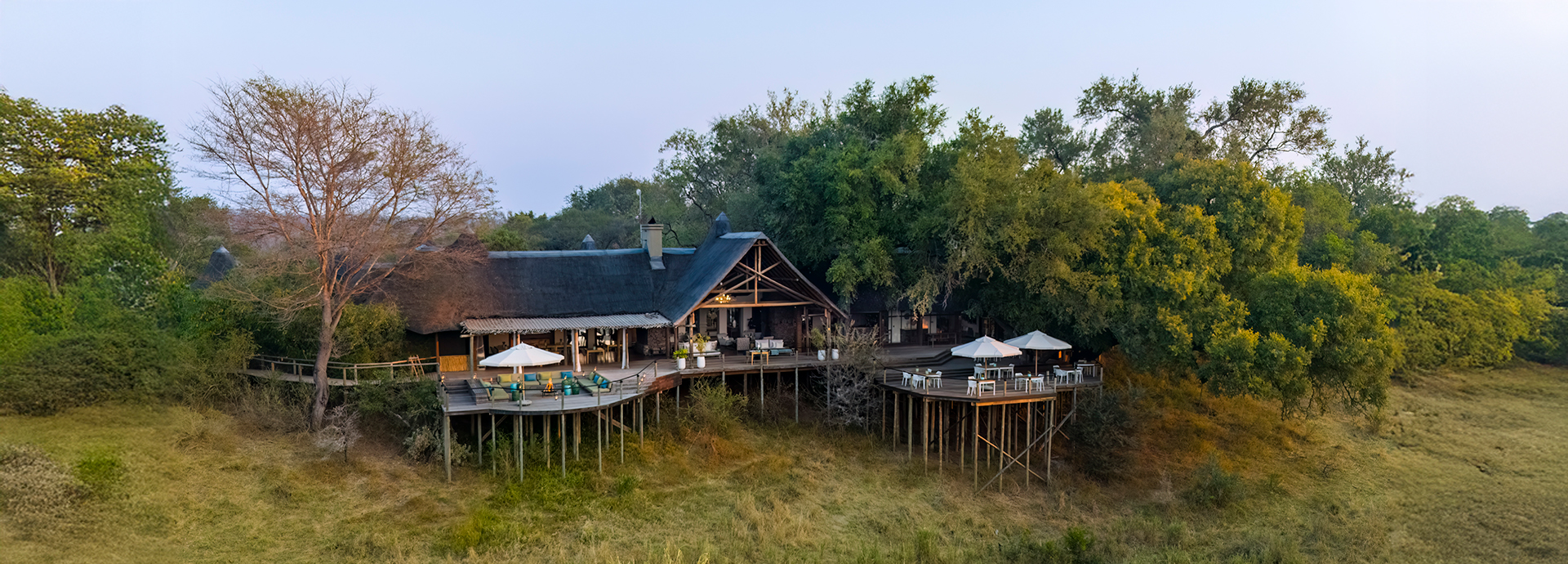 Elevated lodge structure and guest decks extending from forest canopy into the open landscape.