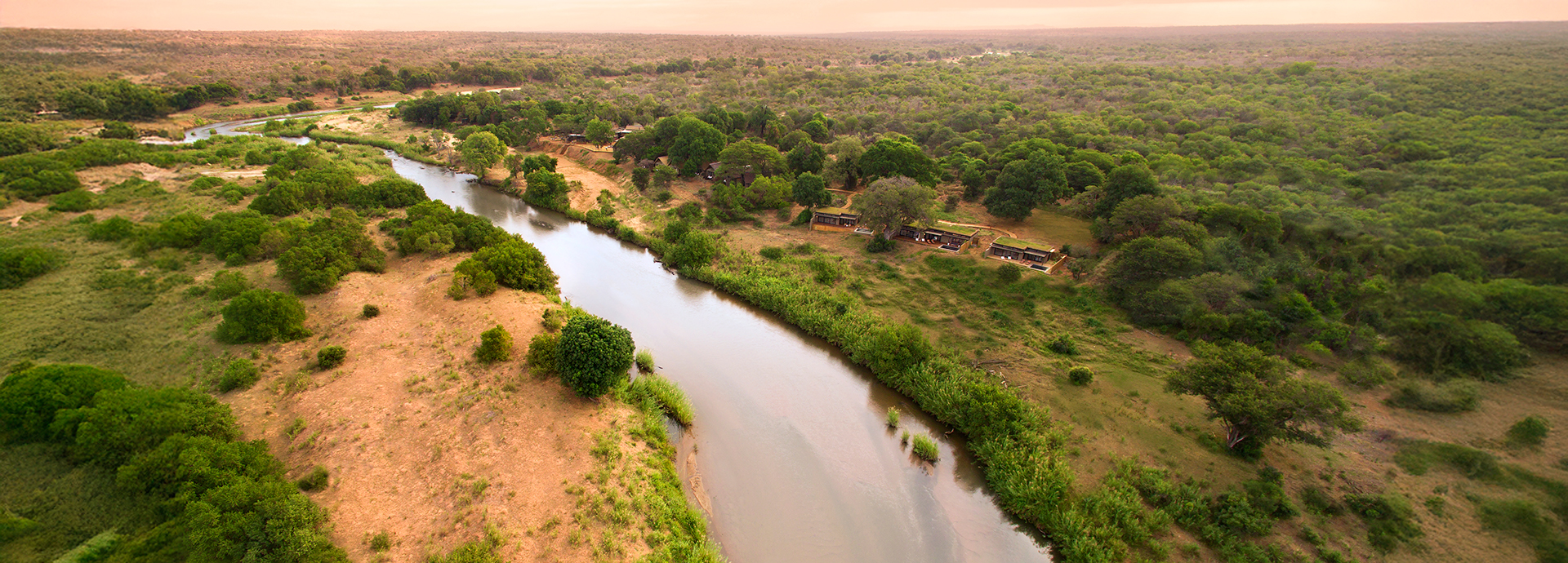 Aerial view of Lion Sands River Lodge along the Sabie River, surrounded by lush vegetation and bushveld.
