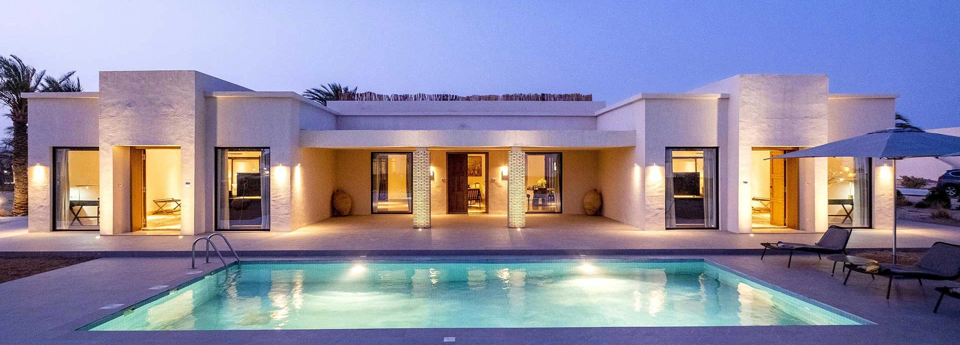 Luxury Royal Oasis Villa at The Residence Douz with a private pool lit at twilight.