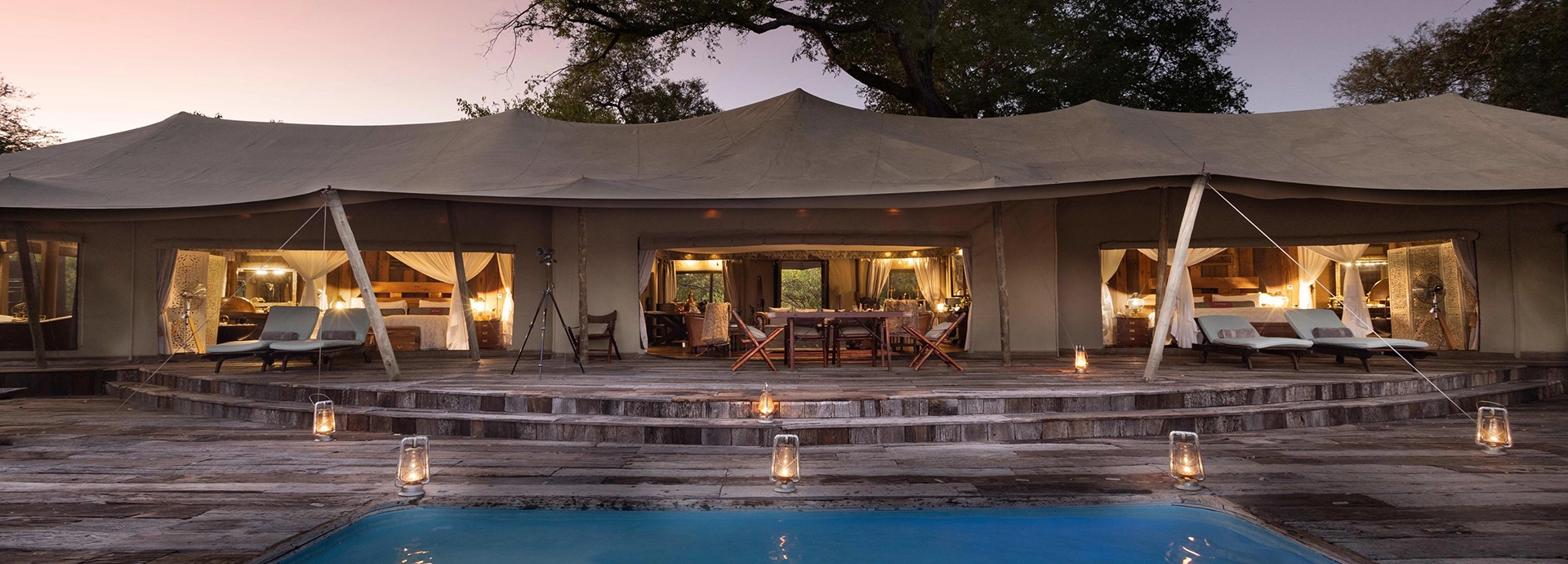 Front-on view of the Zarafa Dhow Suite in the Selinda Reserve, with its private plunge pool in the foreground and lantern-lit deck creating an intimate safari retreat atmosphere.