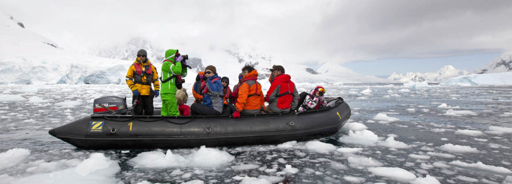 Tourists on a zodiac taking a scenic excursion during Antarctica holidays