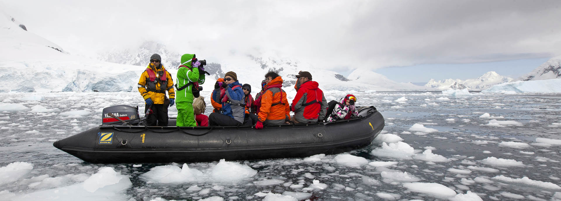 Tourists on a zodiac taking a scenic excursion during Antarctica holidays
