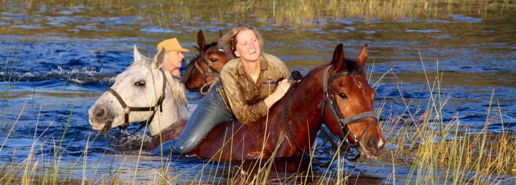 Julie McIntosh, swimming through the Okavango Delta on a horse riding safari with Okavango Horse Safaris