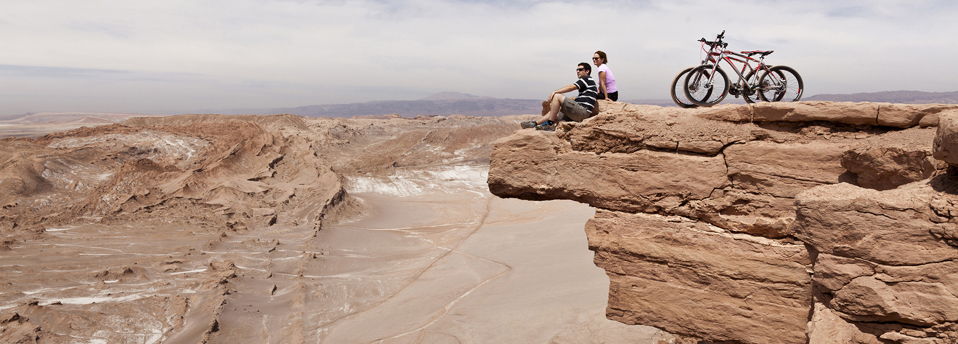Tourists at Chile Explora take a break on a clifftop after exploring the Atacama Desert by bicycle