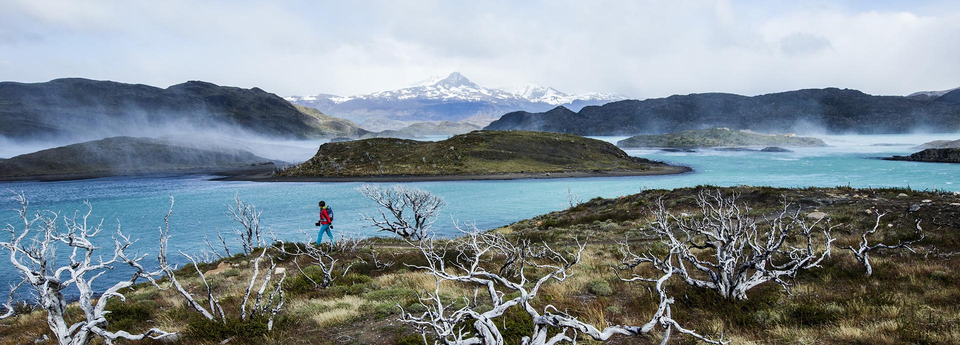 A hiker in the wilderness of Patagonia, passing stunning views of lakes and mountains - a simply unmissable experience of South America travel
