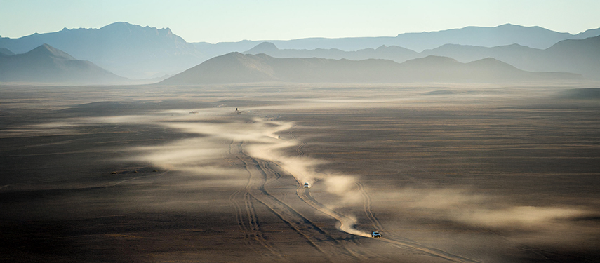Aerial view of four-wheel drive vehicles driving through the Namibian Sossusvlei desert