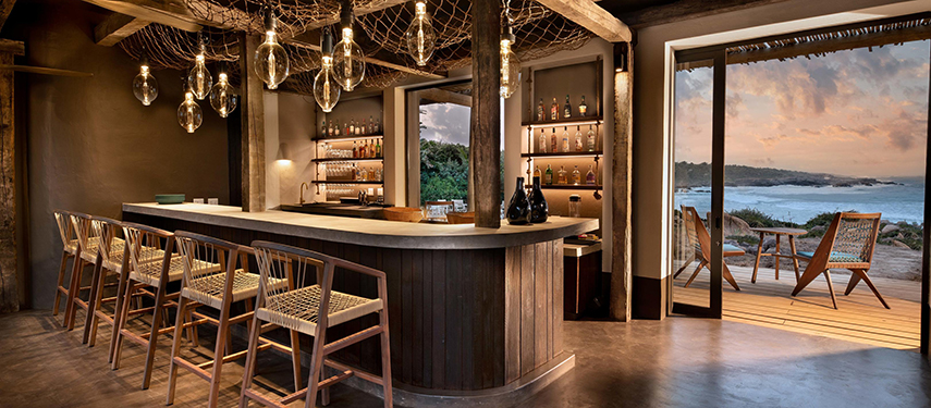Stylish open-air bar area at Gwegwe Beach Lodge with ocean views.