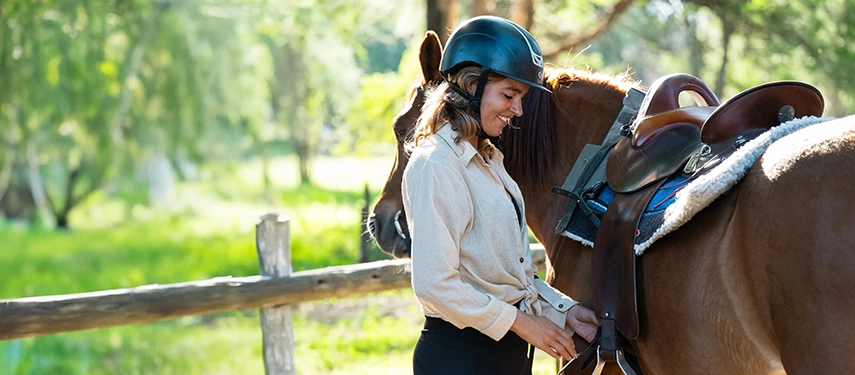 Guest preparing her horse for a morning ride at Chundukwa’s stables.