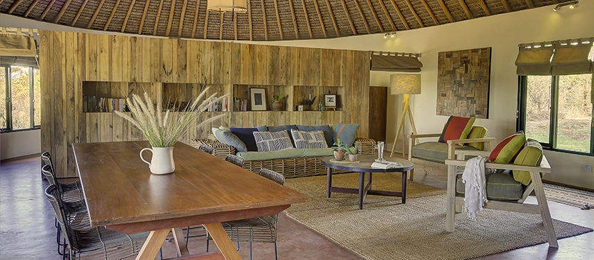 Spacious open-plan living area with rustic wooden furnishings, woven rugs, and soft seating creating a relaxed family atmosphere.