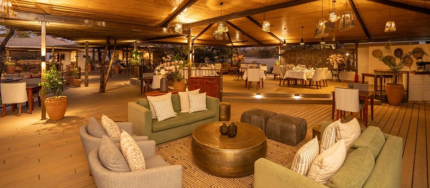 Open-air lounge and dining area with soft lighting and comfortable seating at Insika Lodge, Victoria Falls.
