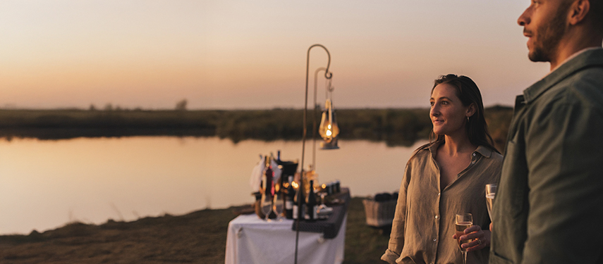 Guest enjoying riverside sundowners in Linyanti, Botswana