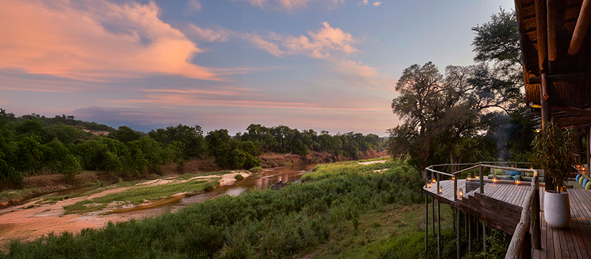 Elevated viewing deck overlooking the Sabie River and lush bushveld at sunrise.