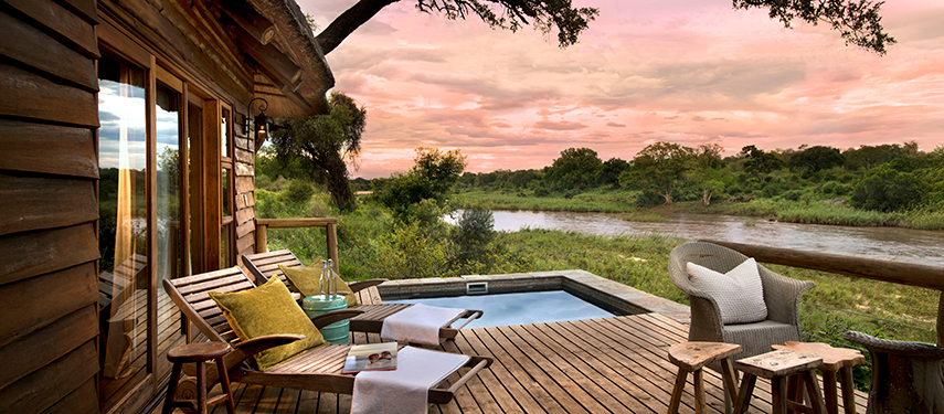 Private deck with plunge pool overlooking the river at sunset, set for tranquil relaxation.
