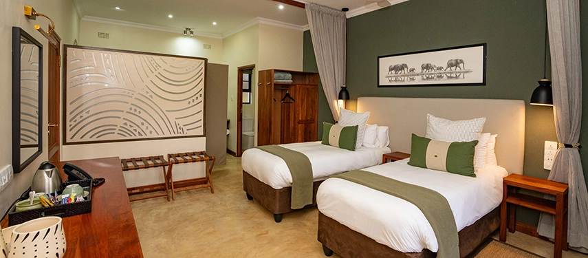 Twin bedroom with contemporary African décor and soft green tones at Insika Lodge, Victoria Falls.