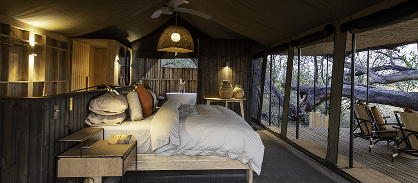 Elegant interior of a luxury tent at Kiri Camp featuring natural materials and serene lighting.