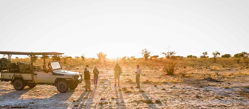 Guests on a game drive at sundown in Botswana