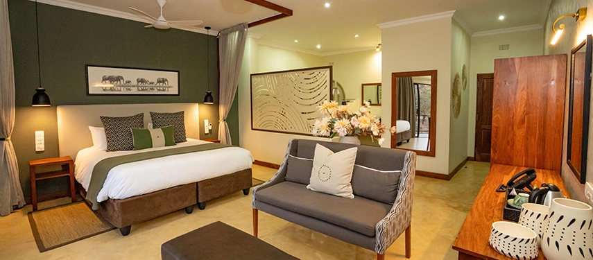 Spacious signature suite with elegant furnishings and warm lighting at Insika Lodge, Victoria Falls.