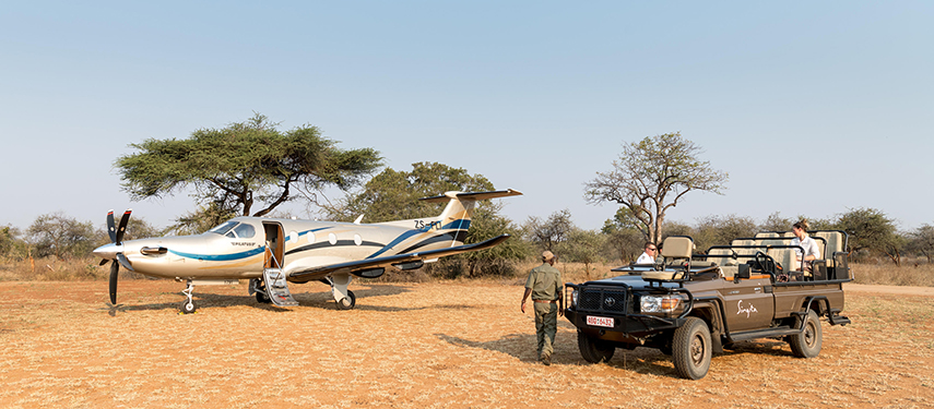 Hosts of a luxury safari lodge collect guests from a private charter flight in Zimbabwe