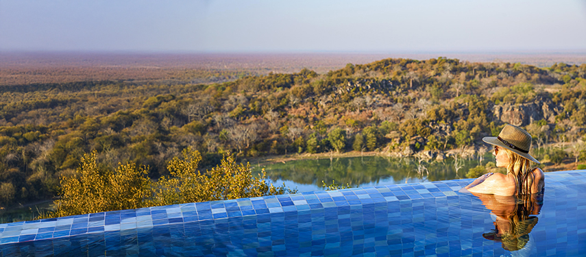 Woman in stunning infinity pool at Singita Malilangwe House, Zimbabwe