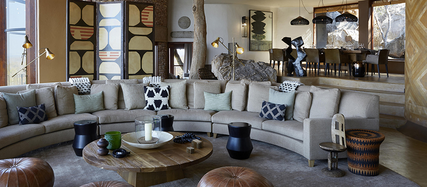 Opulent lounge area filled with African-inspired art and soft furnishings at Singita Malilangwe House