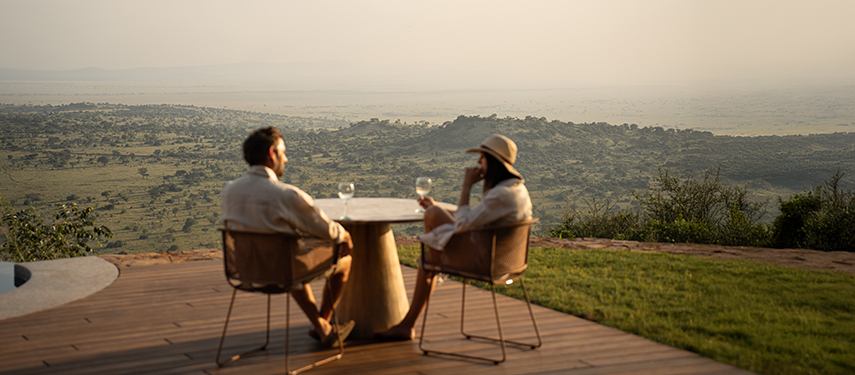 Couple enjoying stunning sunset views over the Serengeti from Singita Milele luxury safari lodge