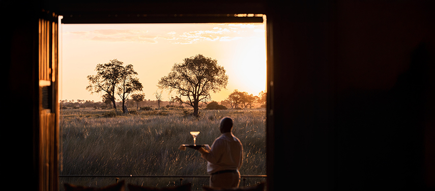 Waiter serving a drink at a luxury safari camp in Botswana