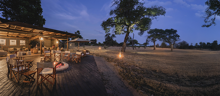 Firepit and open-air lounge at Davison’s Camp lit by lanterns at dusk