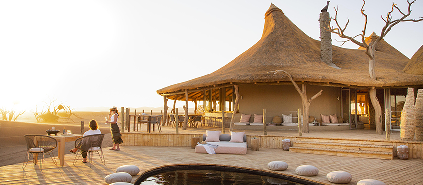 Guests enjoying sundowners Little Kulala luxury safari Camp in Sossusvlei, Namibia