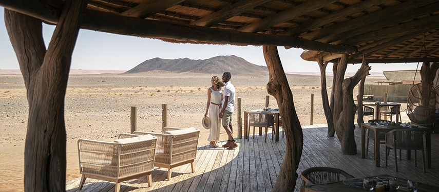 Two guests enjoying the view across the landscape at Little Kulala Camp in Sossusvlei, Namibia