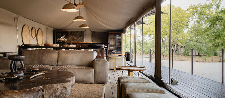 Open-plan lounge area inside the main tent at Little Makalolo with earthy tones and natural textures.
